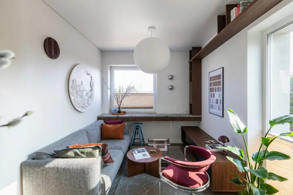 Cozy modern living space with sofa, armchair, and natural light